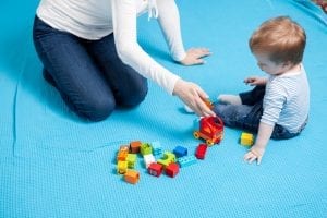 Adult playing on the floor with a toddler doing respite in Toronto.