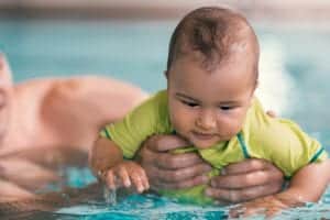 Baby swimming in a pool during a respite services in Toronto session.