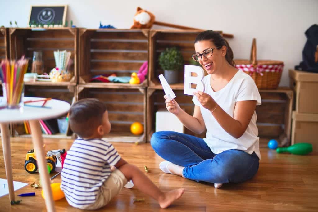 Behaviour Therapist showing a child big block letters in a play room during an ABA therapy in Toronto 
session.